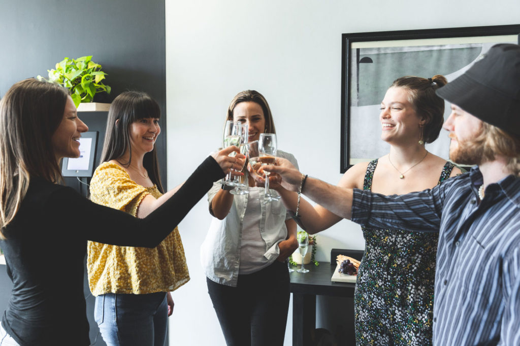 women toasting glasses happily in an office